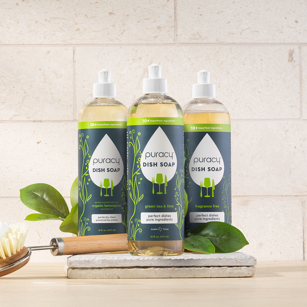 Three bottles of Dish Soap in assorted scents are on a kitchen counter with other cleaning supplies.