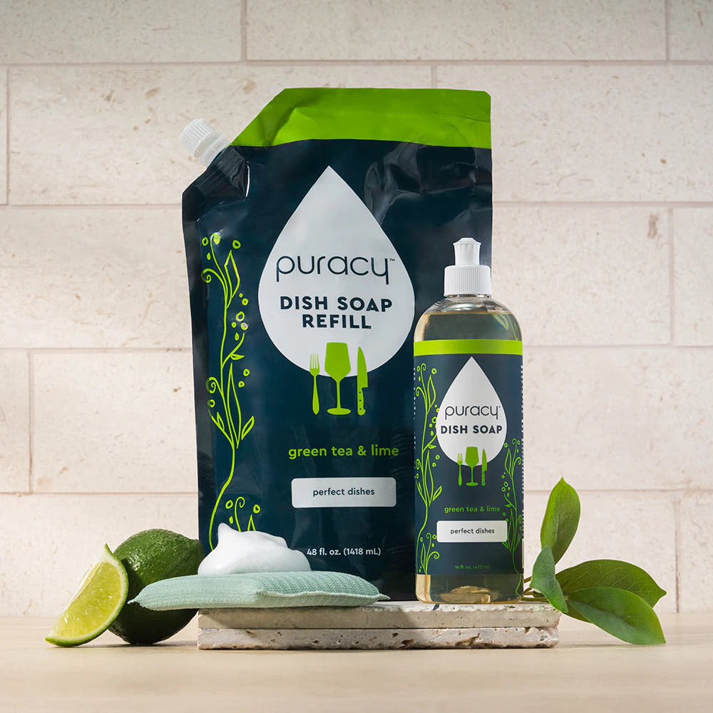 Puracy Dish Soap with green tea & lime, refill pouch and bottle, plus sponge on a countertop.
