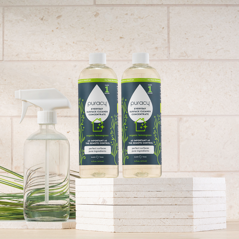 Two Everyday Multi-Surface Cleaner bottles and a spray bottle on stacked white tiles.