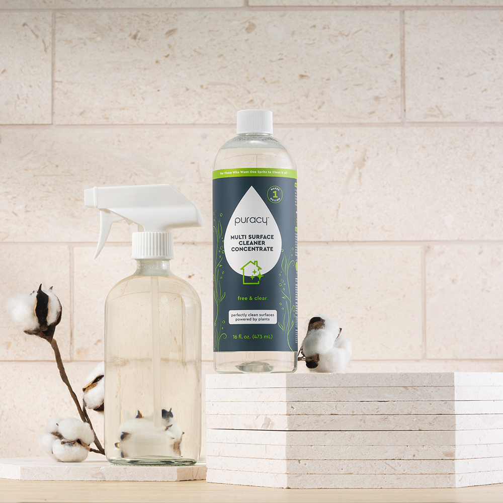 Everyday Multi-Surface Cleaner and clear spray bottle on white surface with cotton stems nearby.