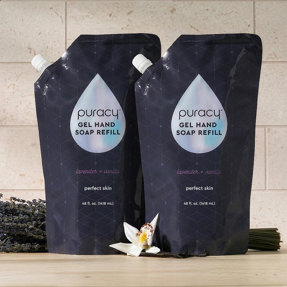 Two black Gel Hand Soap refill pouches with lavender & vanilla, placed beside flowers.