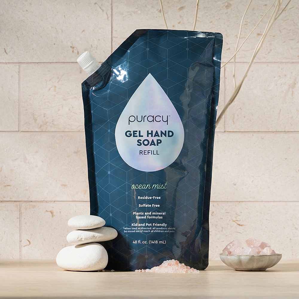Gel Hand Soap with plant-based ingredients on stone, pebbles, and pink bath salts.