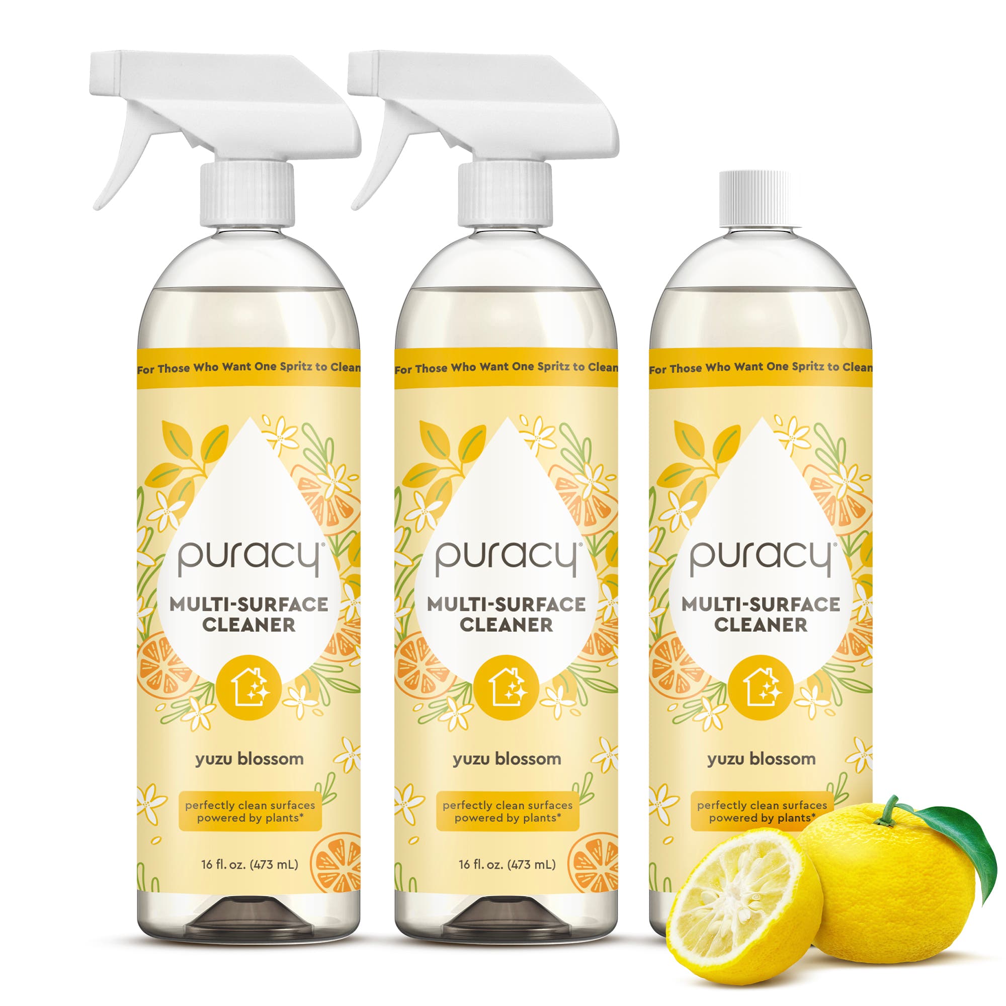 Three Multi-Surface Cleaner Spray bottles with yuzu blossom, beside a sliced yellow yuzu fruit.