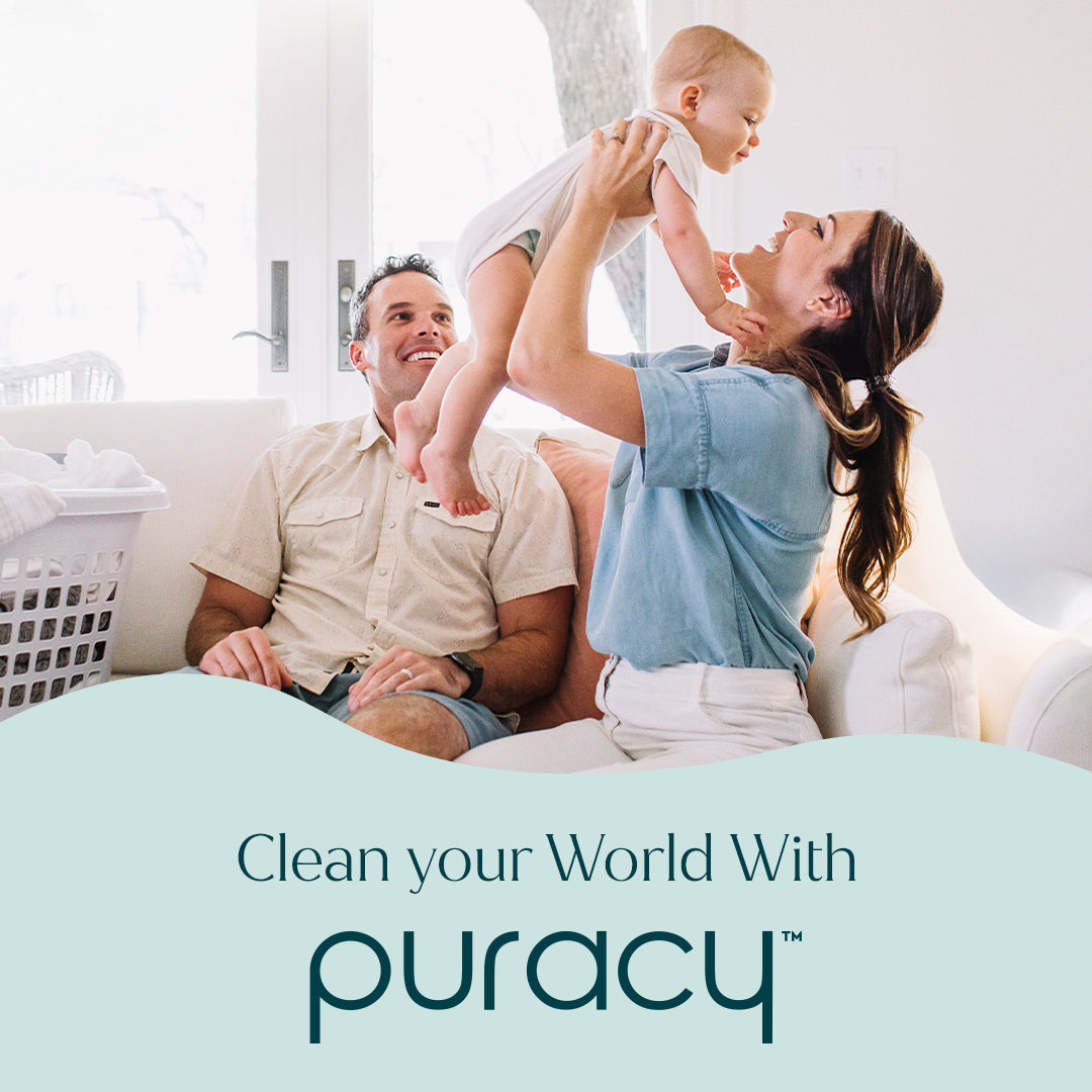 Smiling parents with baby, next to laundry. Text: Clean your world with our Multi-Surface Cleaner Spray. #common