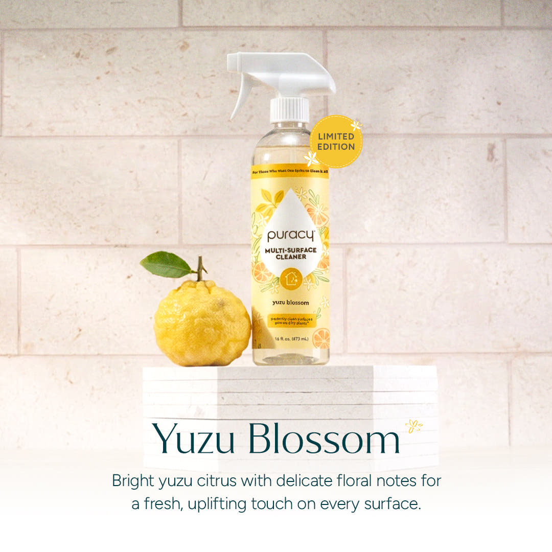 A bottle of Multi-Surface Cleaner Spray beside a yuzu fruit highlights its fresh scent.
