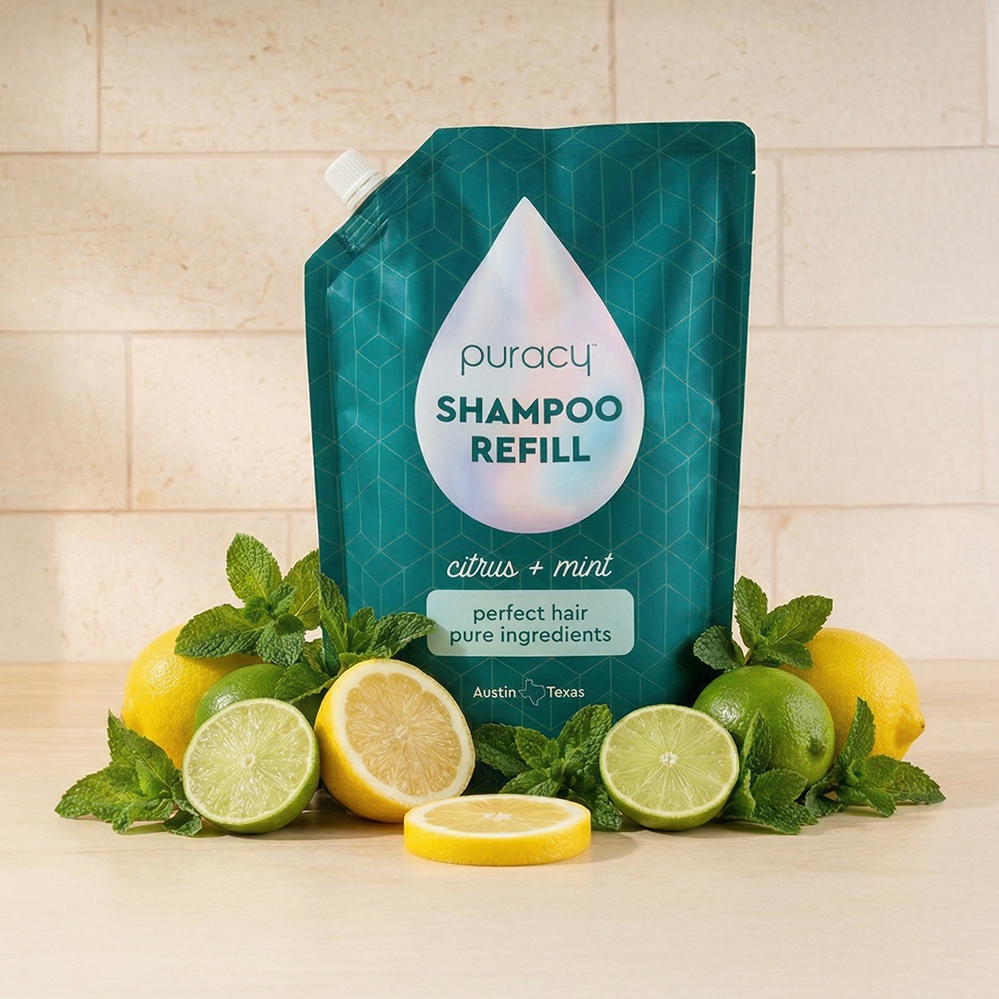 Shampoo (Sulfate/Paraben/Silicone-Free) refill pouch with lemons, limes & mint leaves on a counter.