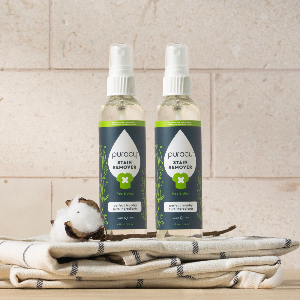 Two bottles of Laundry Stain Remover on a cloth, featuring powerful stain-fighting enzymes.