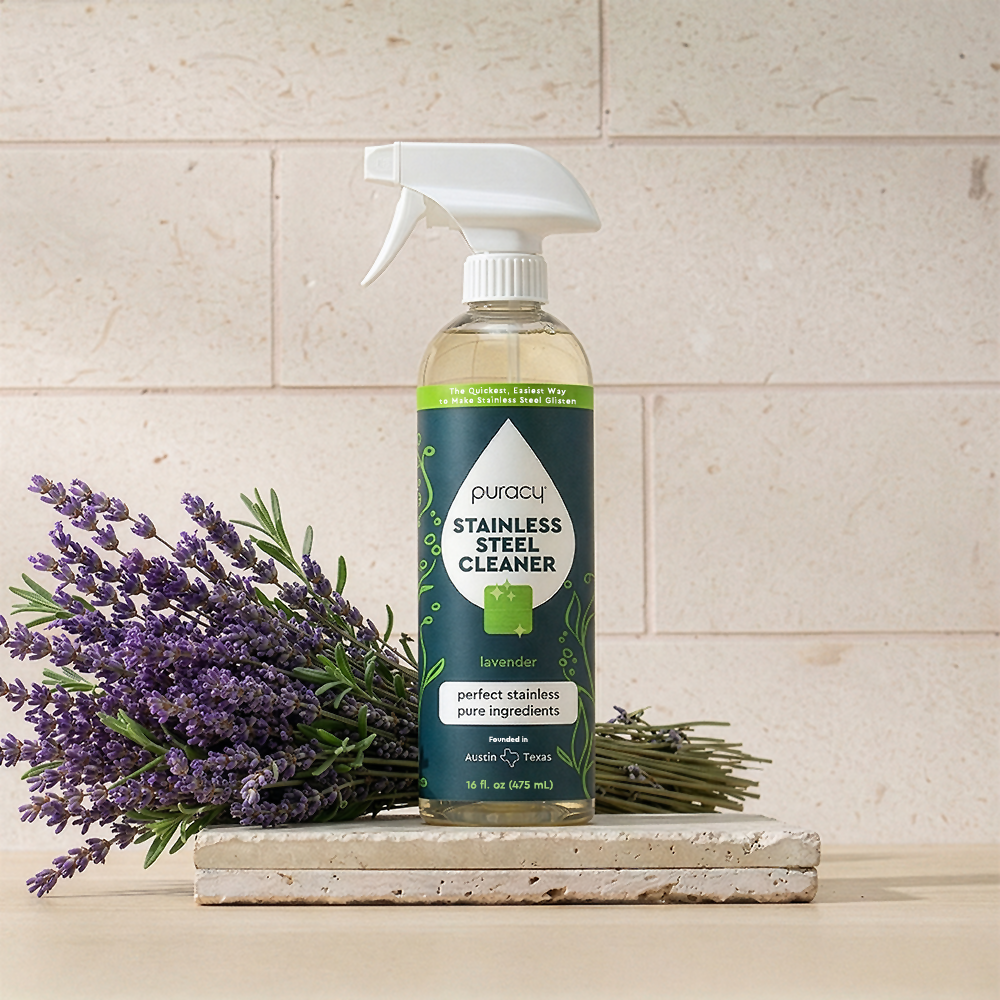 A Stainless Steel Surface Cleaner bottle sits on a stone slab before beige tiles.