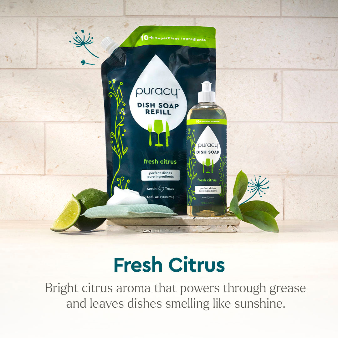 Dish Soap with citrus fruits and green leaves pictured on a counter, includes refill pouch. #common #scent_fresh-citrus