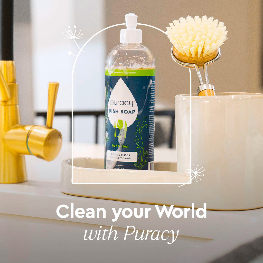 A bottle of Dish Soap and a brush sit on a white countertop near a gold faucet.