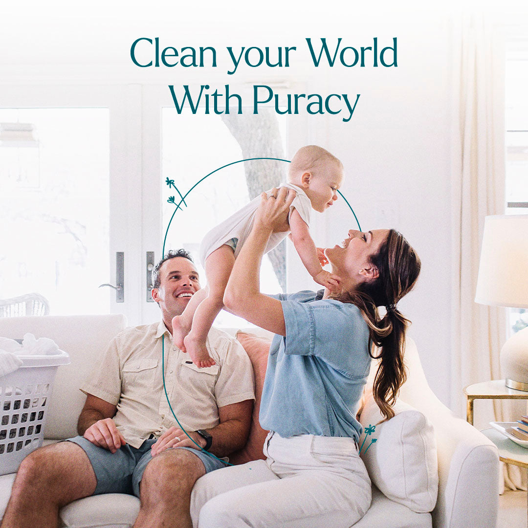 A woman lifts a baby as a man smiles beside them, with Laundry Stain Remover nearby.