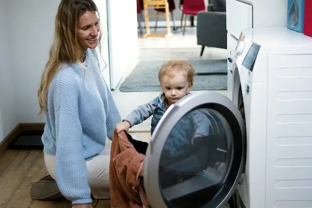 baby having laundry with mom