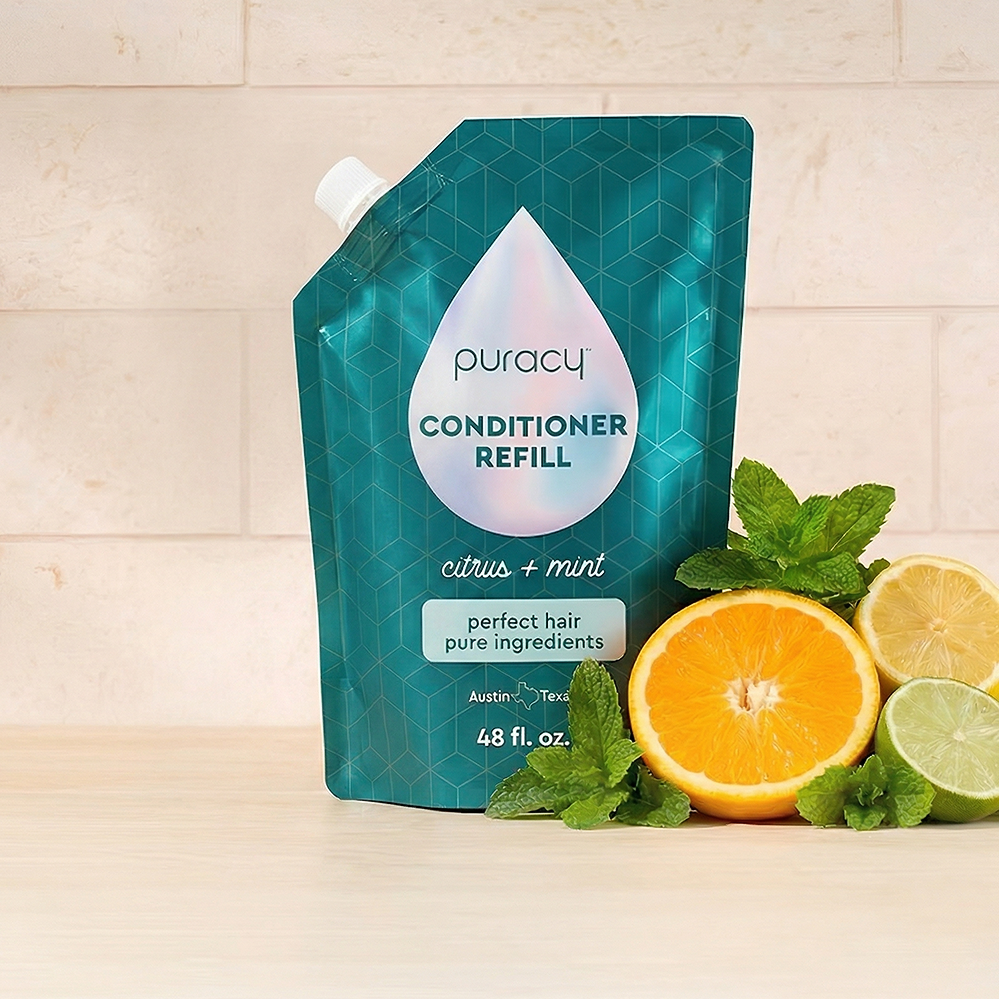 Puracy Conditioner (Silicone/Dimethicone/Sulfate Free) refill pouch with citrus and mint on wood.