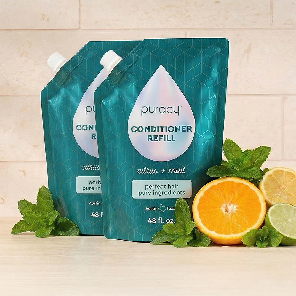 Two teal pouches of sulfate-free Conditioner with citrus, mint, and essential oils surround them.