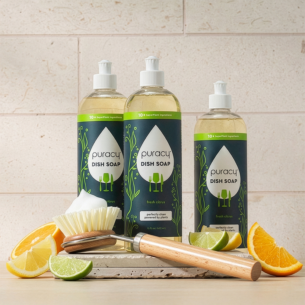 Three bottles of Dish Soap with citrus scent and a dish brush displayed in front.