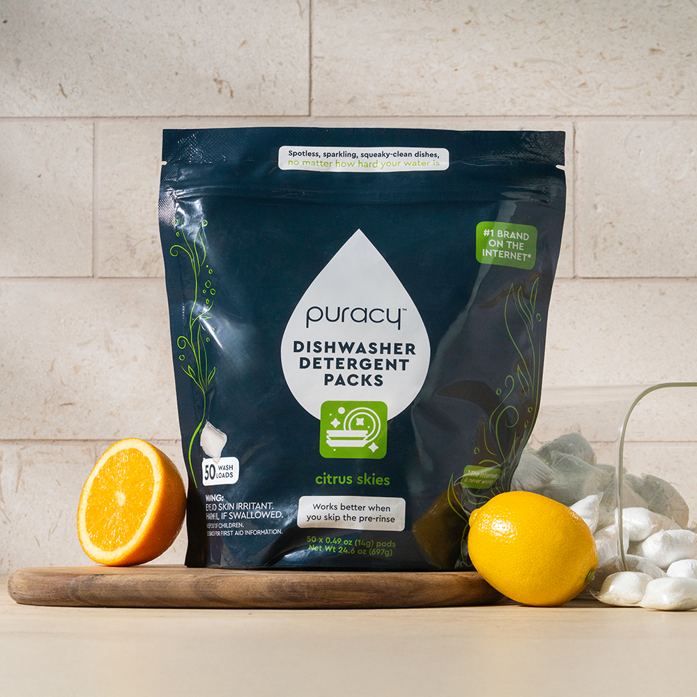 Dishwasher Detergent Pods with plant-based formula, shown with citrus and lemon on a counter.
