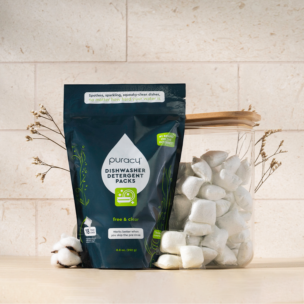 Dishwasher Detergent Pods with a plant-based formula sit next to a jar on the countertop.