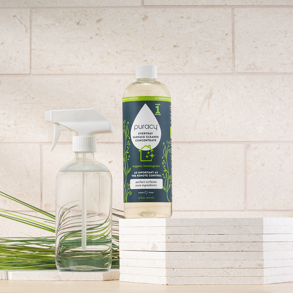 Everyday Multi-Surface Cleaner sits by stacked tiles and green grass on the counter.
