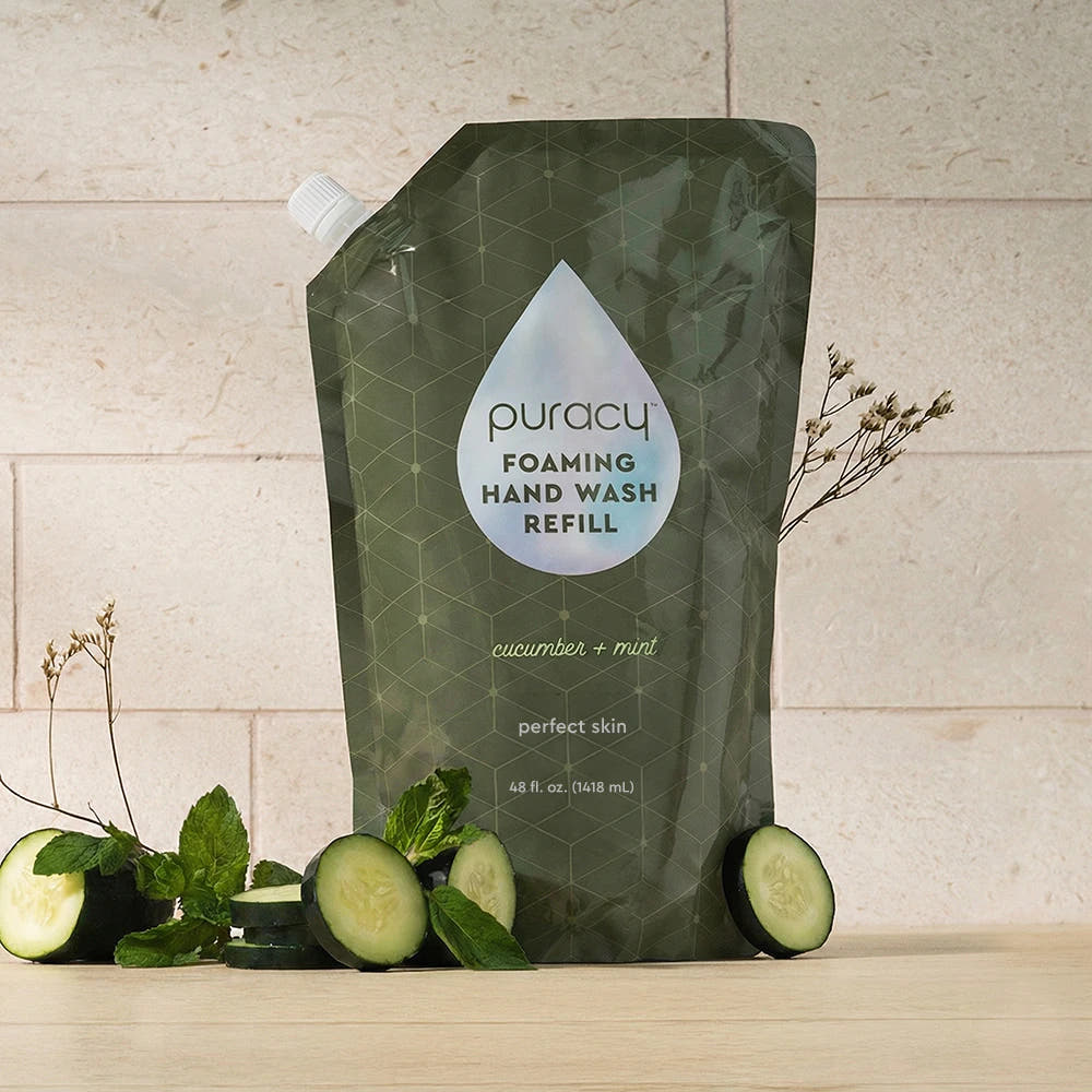 A Foaming Hand Soap refill with cucumbers and mint sits on a wooden surface.