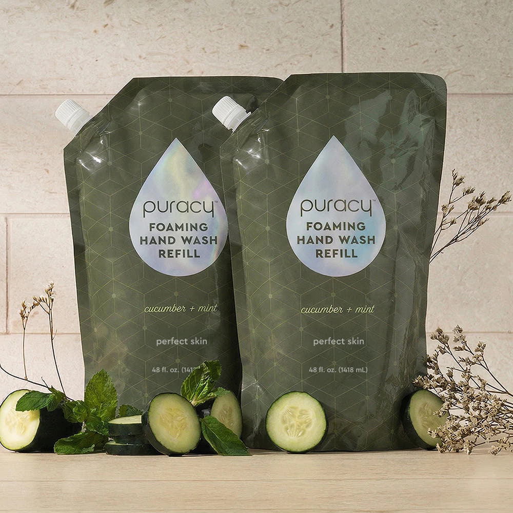 Two Foaming Hand Soap refill pouches with cucumber, mint, and small sprigs beside them.