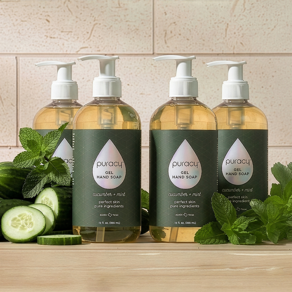 Four bottles of Gel Hand Soap with plant-based ingredients are next to cucumbers and mint.