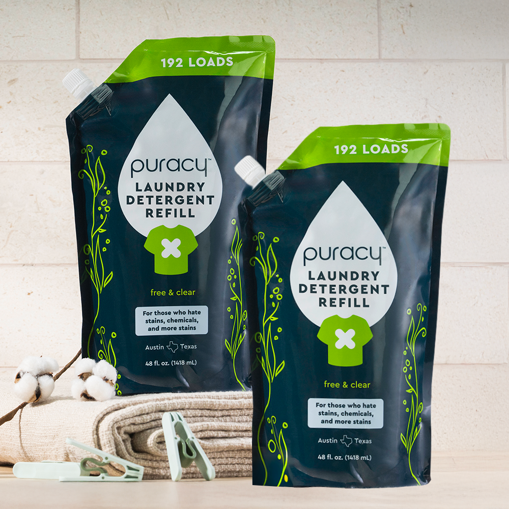 Two Laundry Detergent (Concentrated, Sulfate-Free) pouches on a table with towels and clothespins.