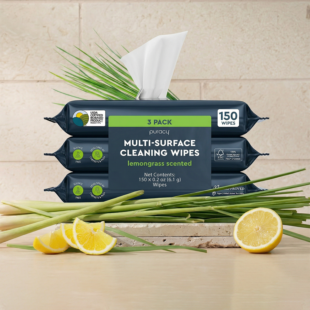 Three packs of Multi-Surface Cleaner Wipes, lemongrass-scented, shown with lemon and lemongrass.