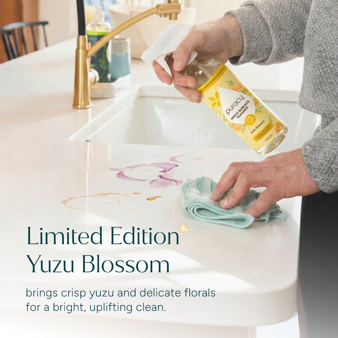 A person wipes a kitchen counter with a cloth and Multi-Surface Cleaner Spray.