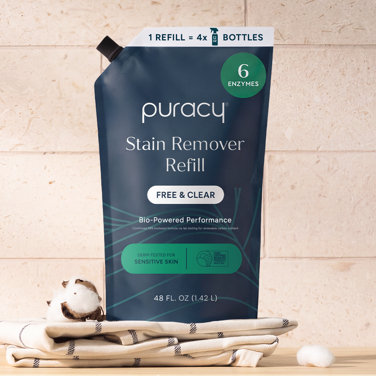 Laundry Stain Remover refill pouch on folded towels with a cotton boll nearby.