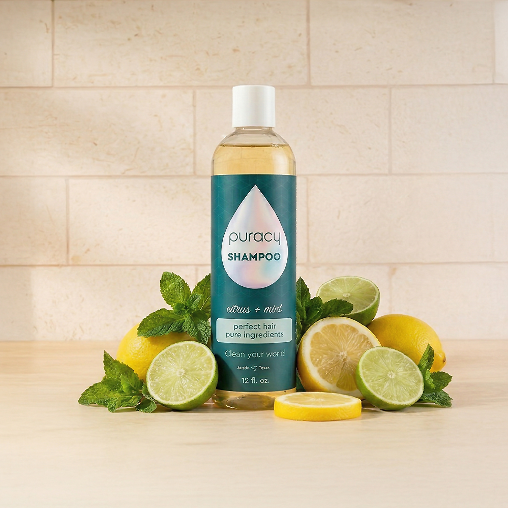 Shampoo (Sulfate/Paraben/Silicone-Free) bottle with lemons, limes, and mint leaves on a countertop.