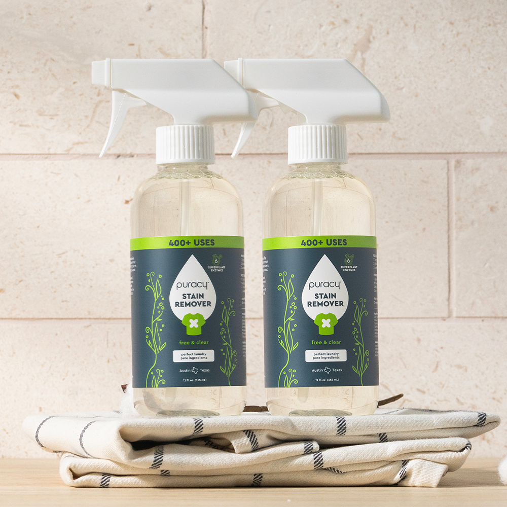 Two bottles of Laundry Stain Remover sit on a towel, packed with powerful stain-fighting enzymes.