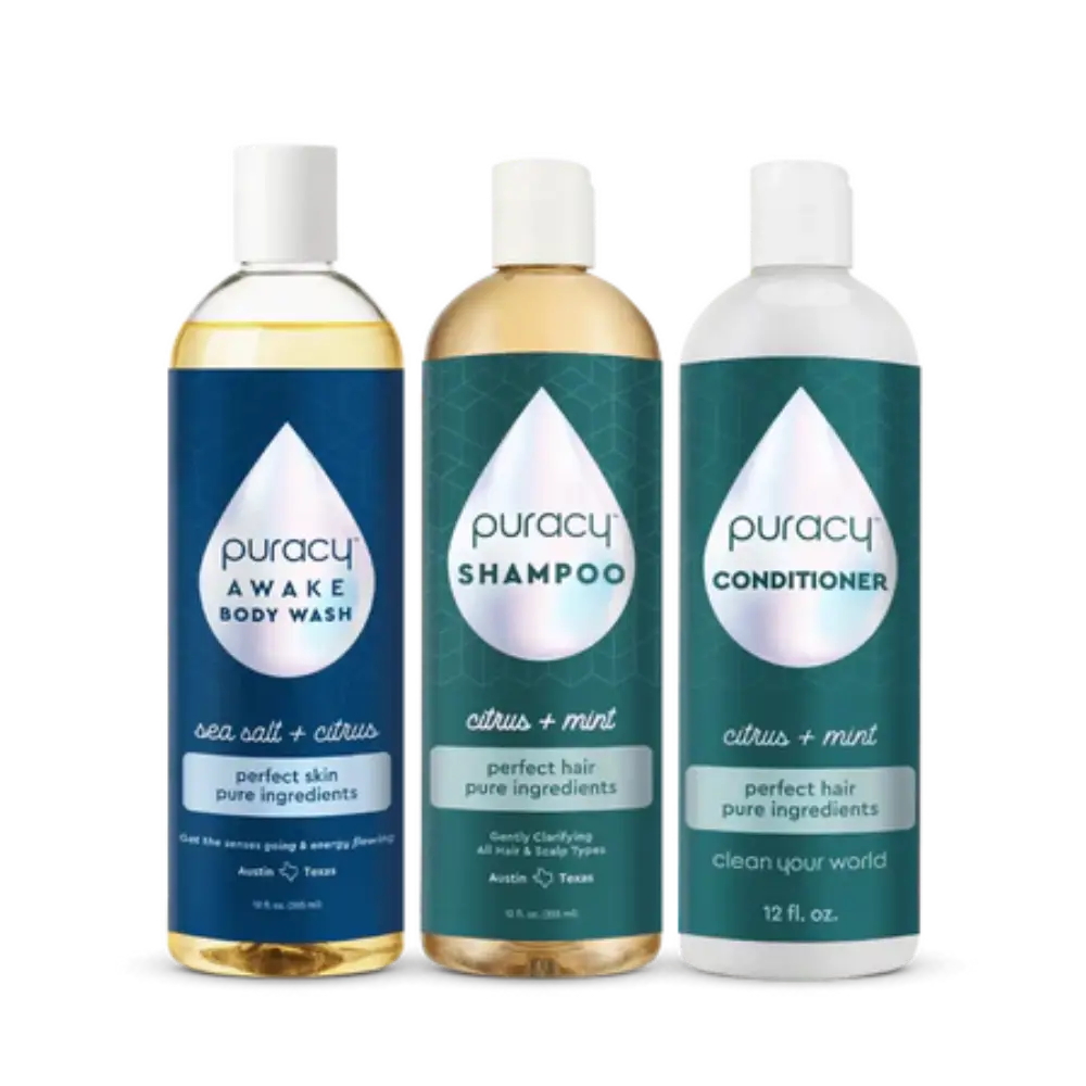 The Under the Shower Bundle from Puracy includes bottles of gentle shampoo, natural body wash, and conditioner, all featuring a citrus-themed design and placed side by side.