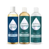 The Under the Shower Bundle from Puracy includes bottles of gentle shampoo, natural body wash, and conditioner, all featuring a citrus-themed design and placed side by side.