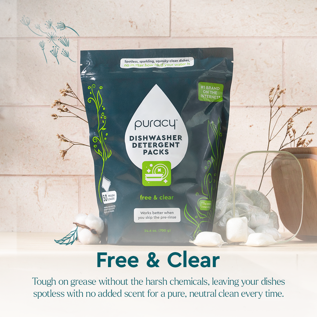 A bag of Puracy Dishwasher Detergent Pods sits on a table with cotton and glassware nearby.